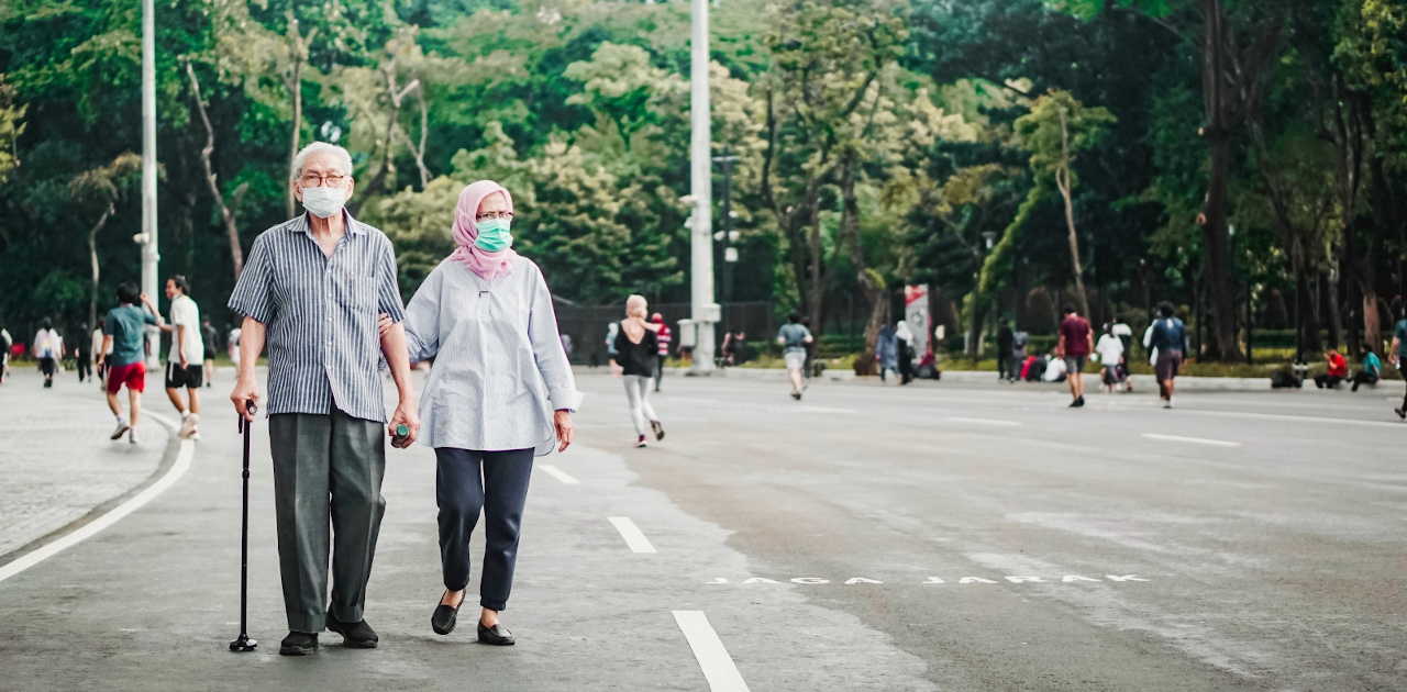 Jakarta, Indonesia - December 9th, 2020 - Selective focus photo of an elderly couple wearing face masks watching people jog