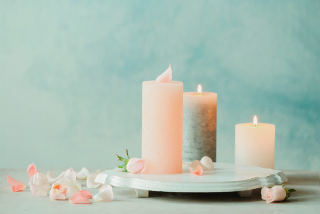 Candles,With,Floral,Decor,On,Table,Against,Color,Background