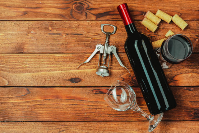 Red,Wine,Bottle,,Wine,Glass,And,Corkscrew,On,Wooden,Table